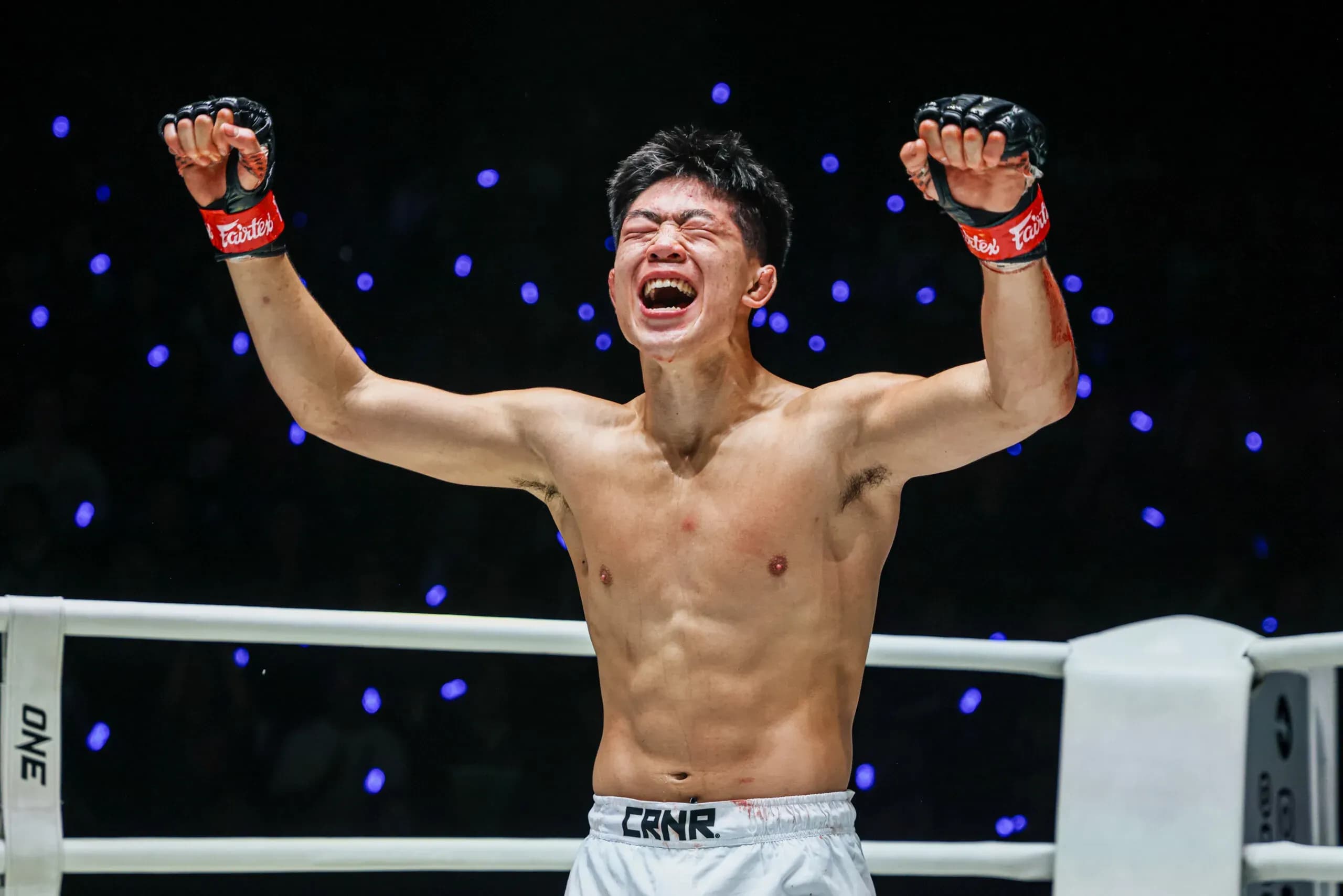 MMA fighter Adrian Lee raises his arms following his victory