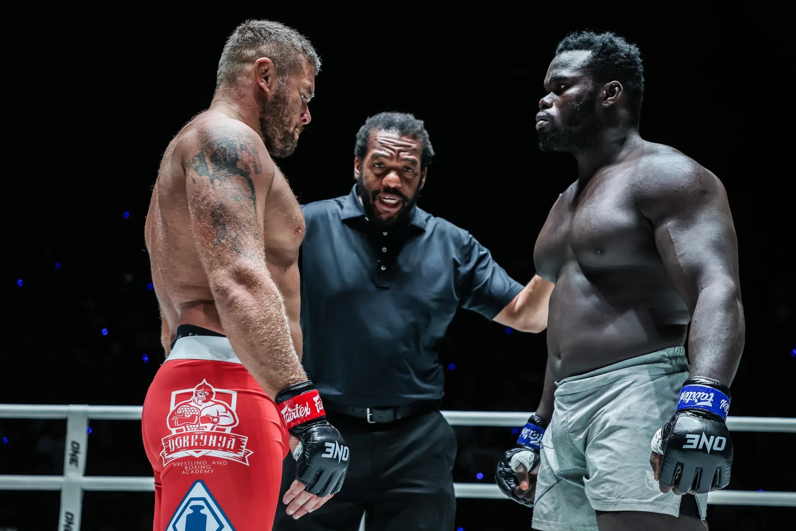 Anatoly Malykhin and "Reug Reug" Oumar Kane stand face to face with Herb Dean between them