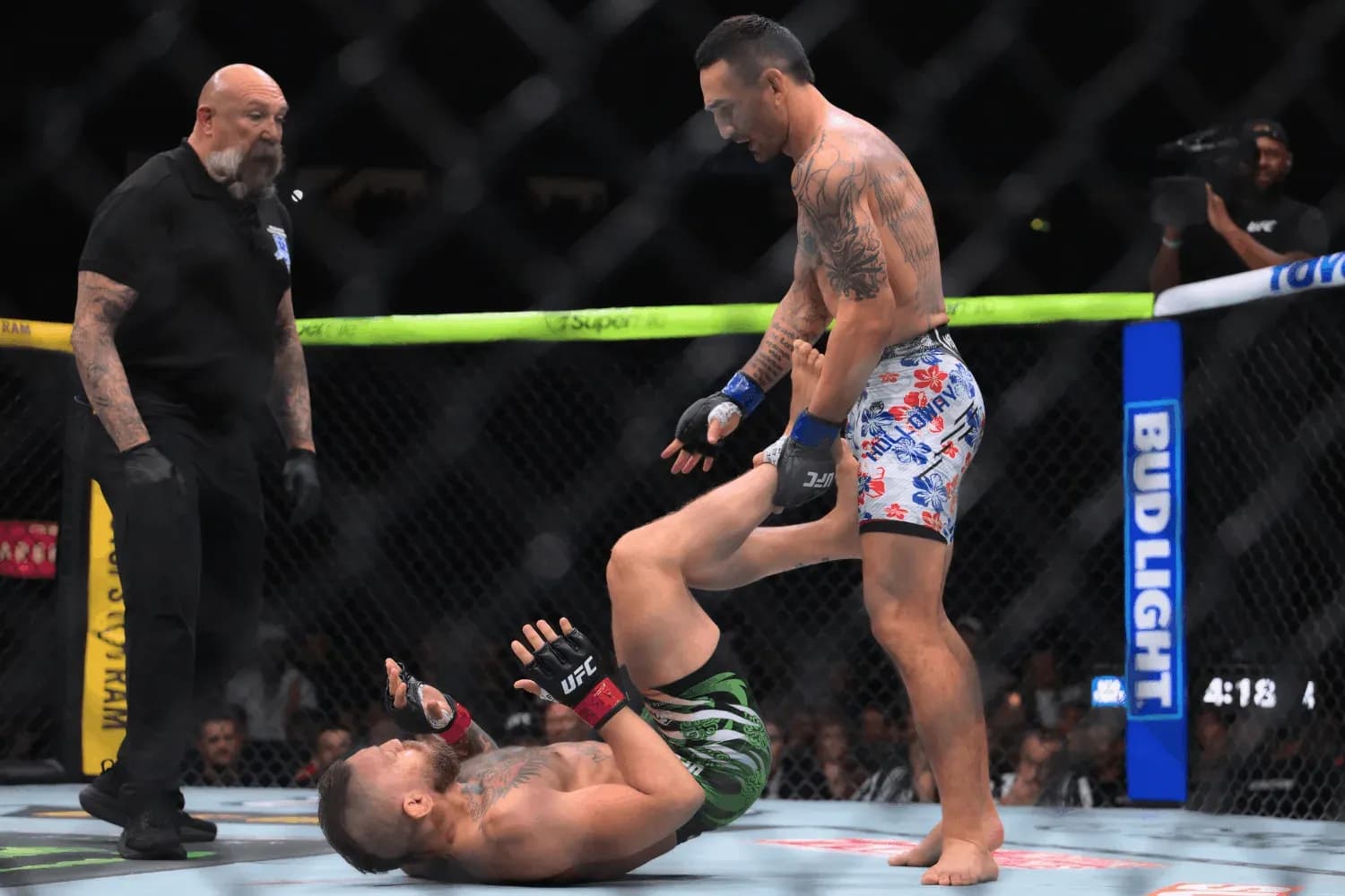 Conor McGregor on the canvas as Max Holloway engages with him