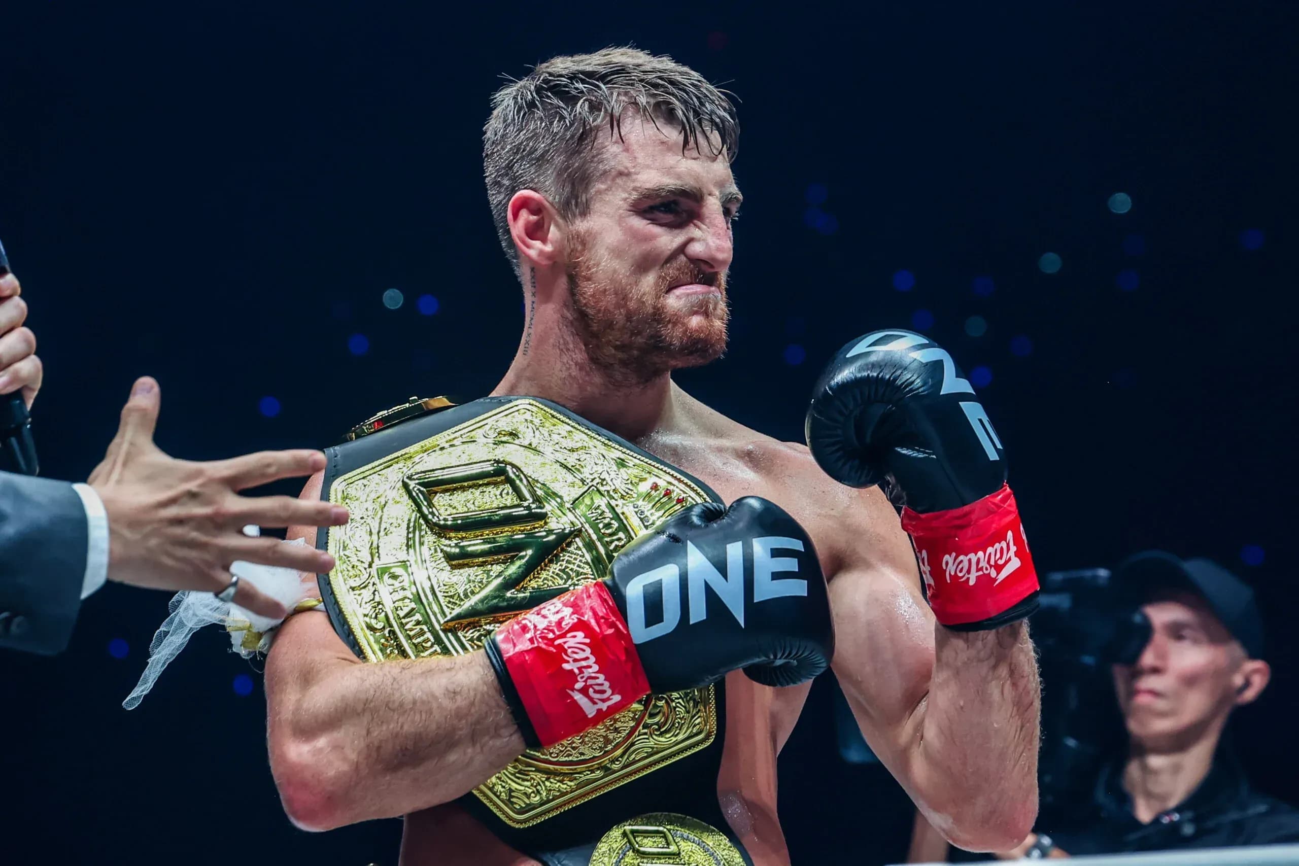 British kickboxer Jonathan Haggerty holds the ONE Championship belt and raises his fist