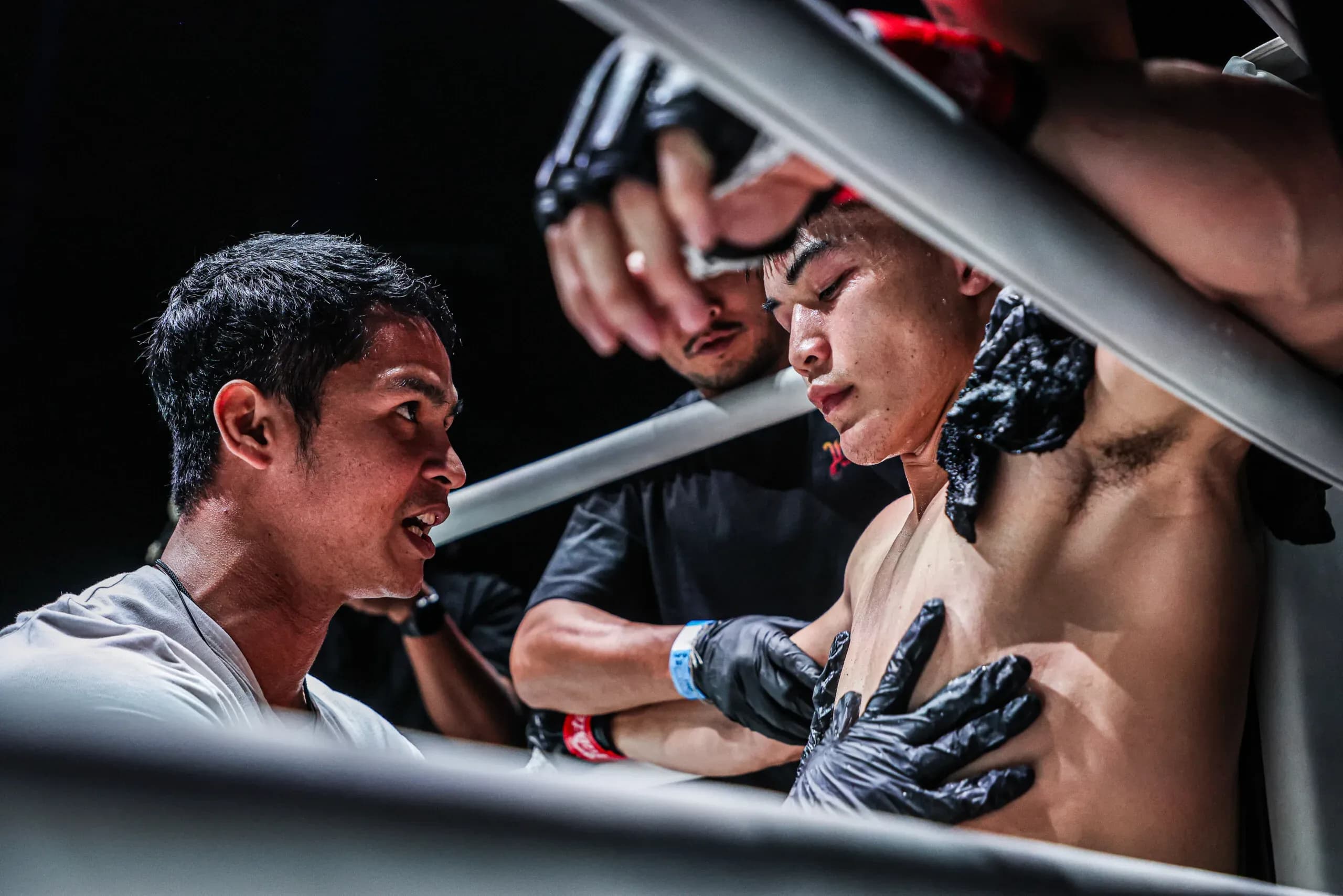 Superbon and Nong-O give Rambolek advice in the corner in between rounds