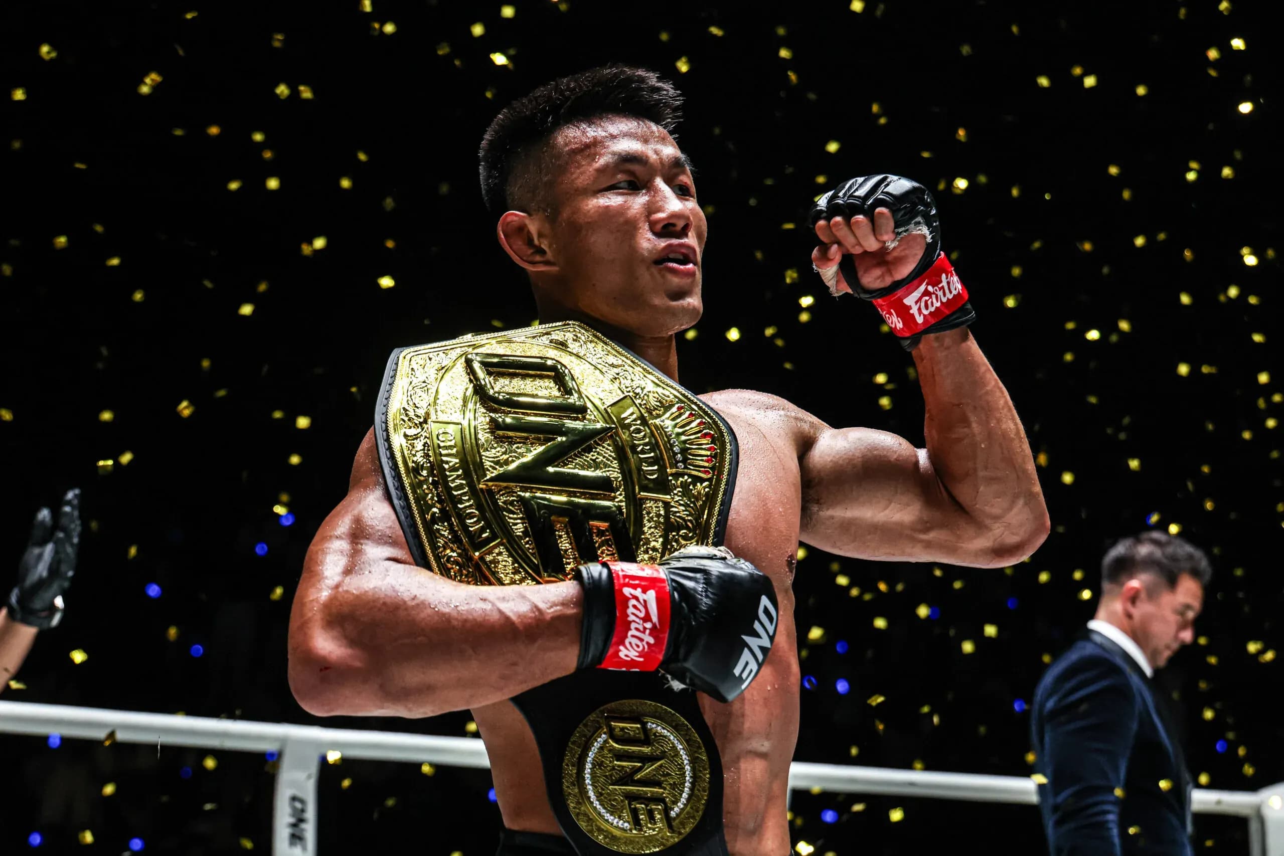Chinese MMA sta Tang Kai pumps his first with the ONE Championship belt over his shoulder