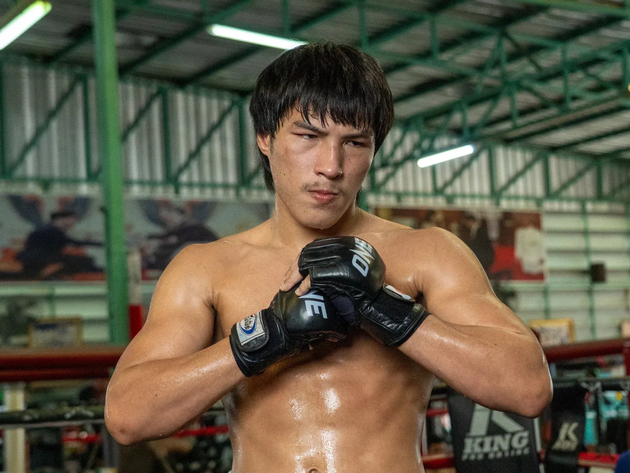 Muay Thai fighter Yod-IQ Or Pimolsri rubs his gloves at an open workout