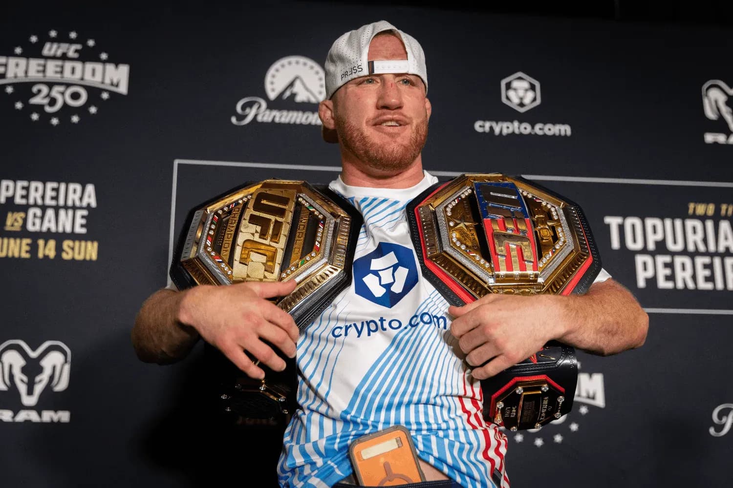 Justin Gaethje poses with two belts 
