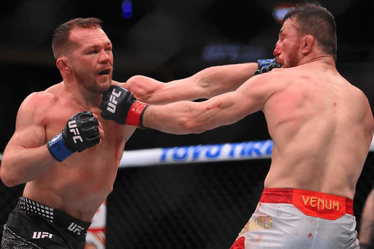 Petr Yan (left) punches Merab Dvalishvili (right)