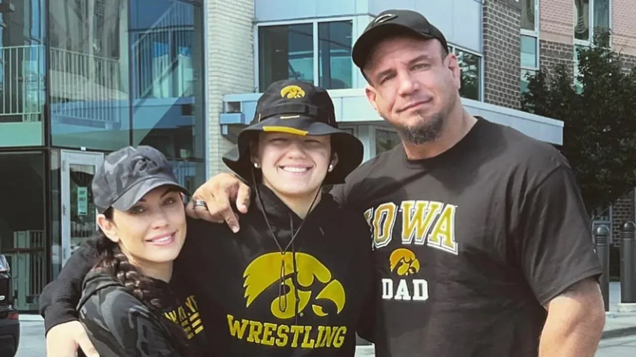 Frank and Bella Mir posing for a photo after Bella announces her commitment to the University of Iowa wrestling team.