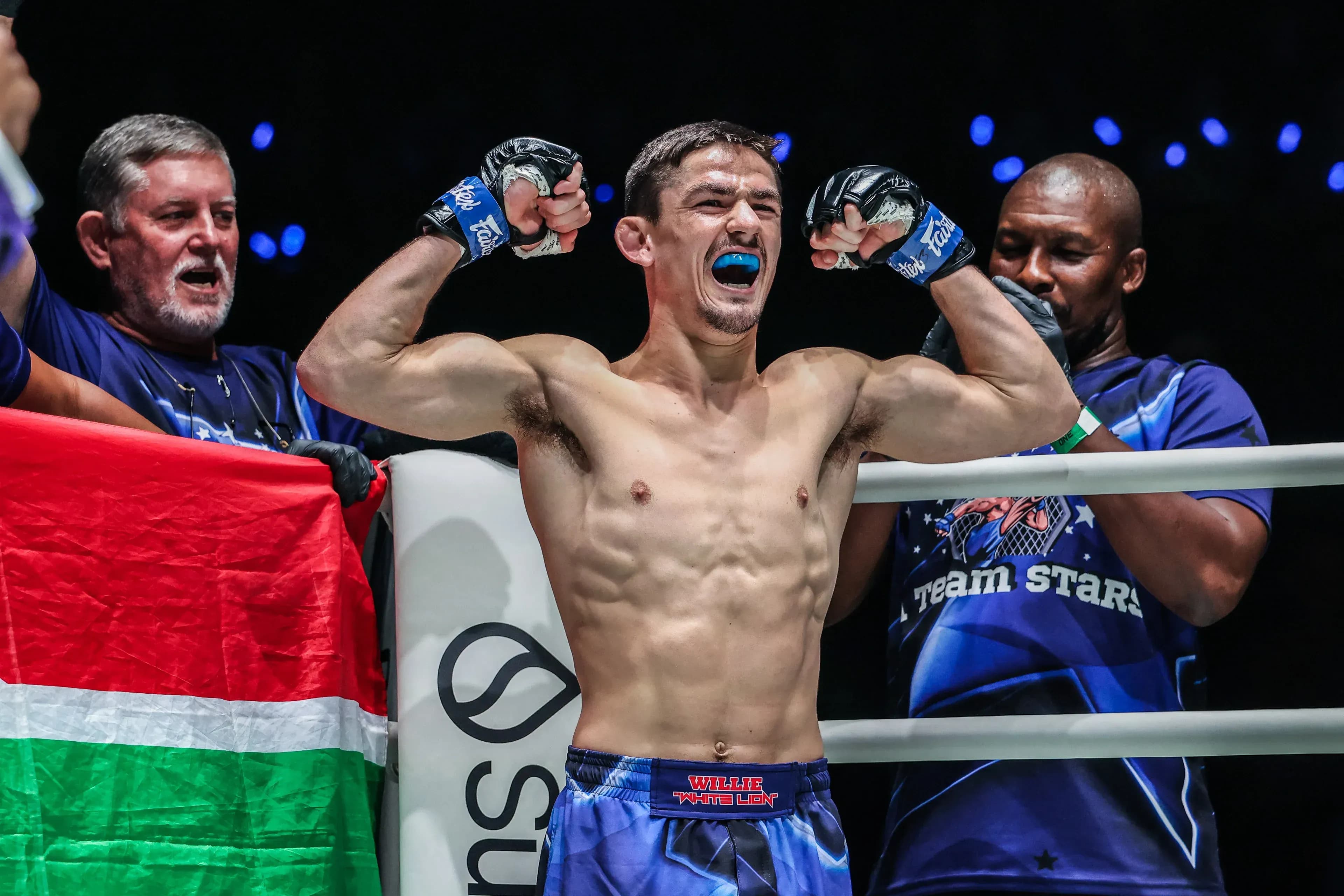 South African MMA fighter Willie van Rooyen flexes in the ring