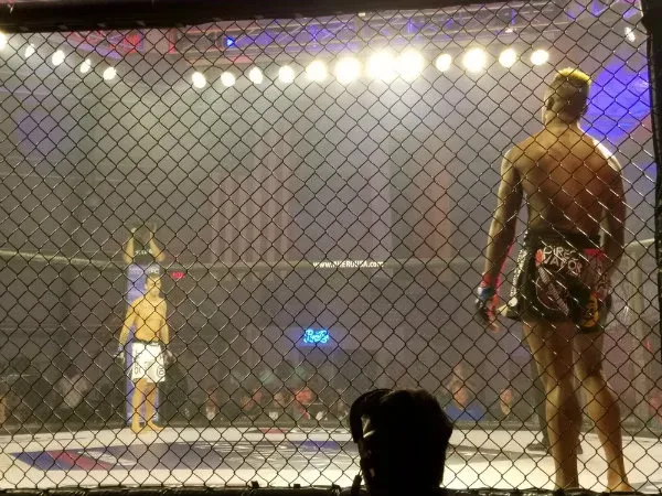 Caio Rocha and Peter "The Joker" Petties mean mug one another from across the Titan FC cage.