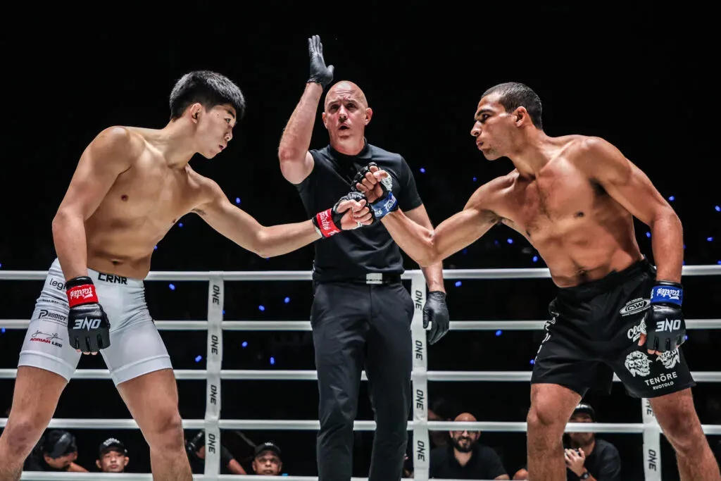 Adrian Lee and Tye Ruotolo touch gloves in the ring before their MMA bout