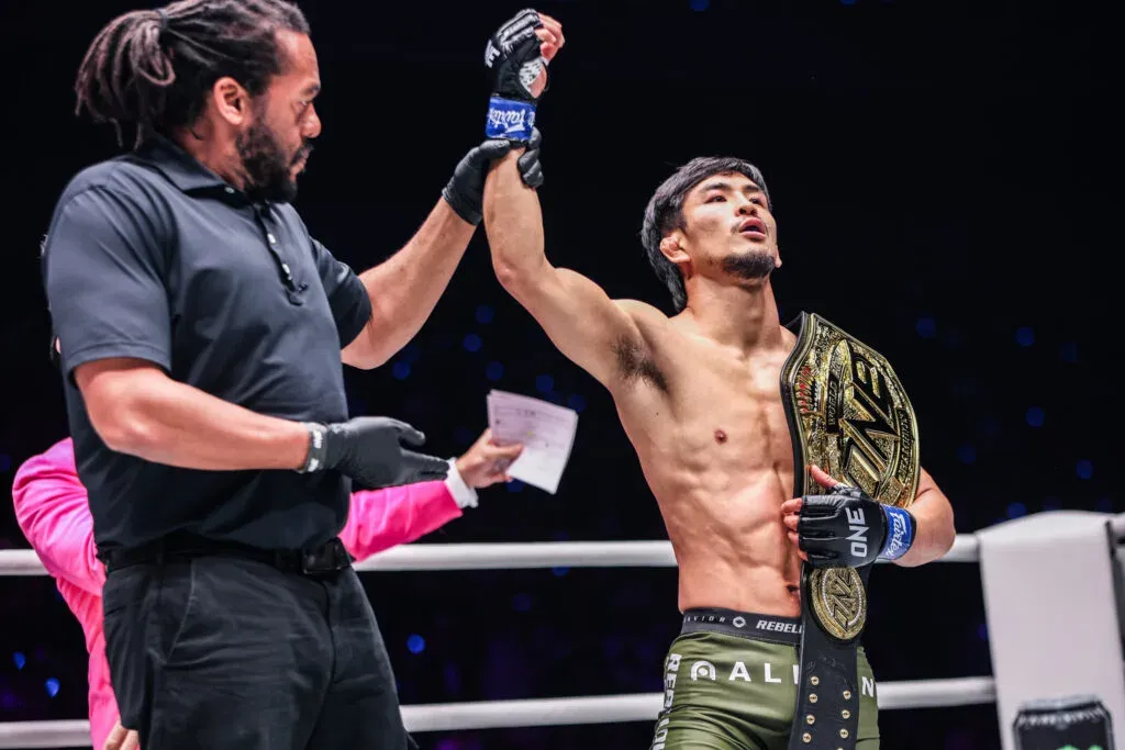 Referee Herb Dean raises MMA Champion Yuya Wakamatsu's hand, as he holds the ONE Championship belt