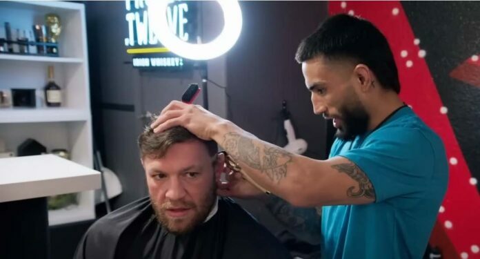 Conor McGregor receives a haircut from Mando Gutierrez on The Ultimate Fighter.
