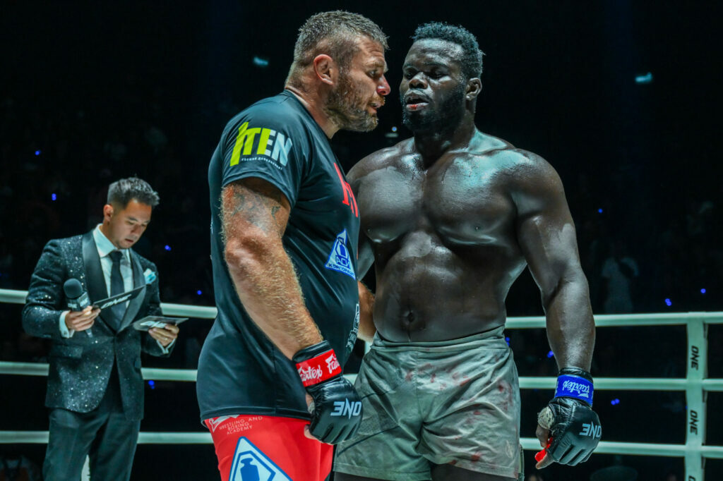 Anatoly Malykhin stands with Reug Reug Oumar Kane in the cage