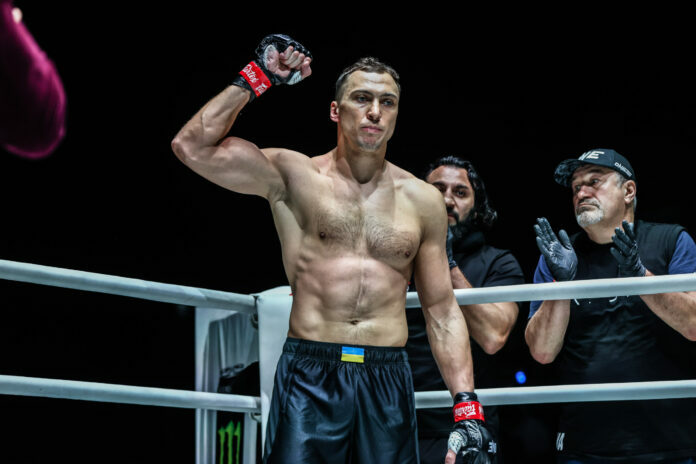 Roman Kryklia raises his arm in the air