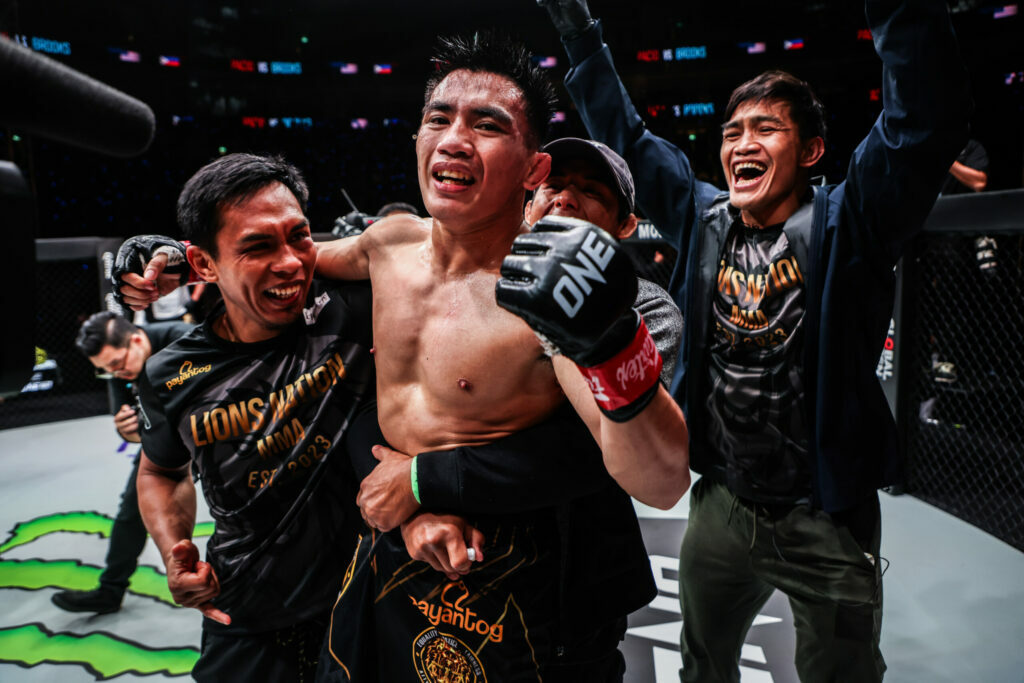 Joshua Pacio celebrates a win with his team inside the cage