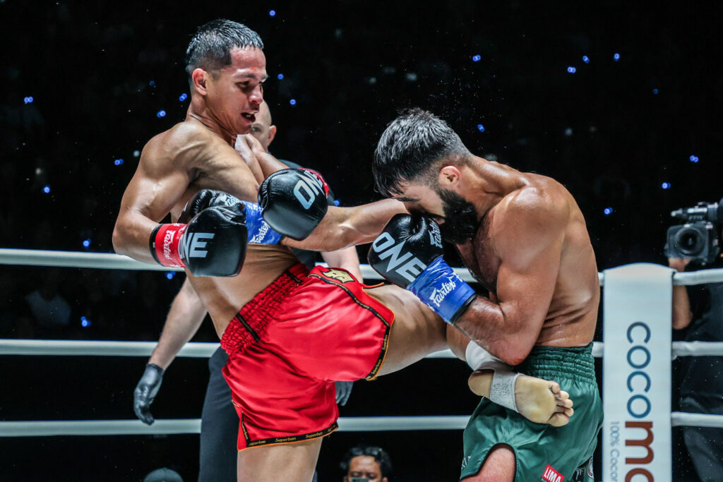 Superbon launches a knee into Marat Grigorian's body