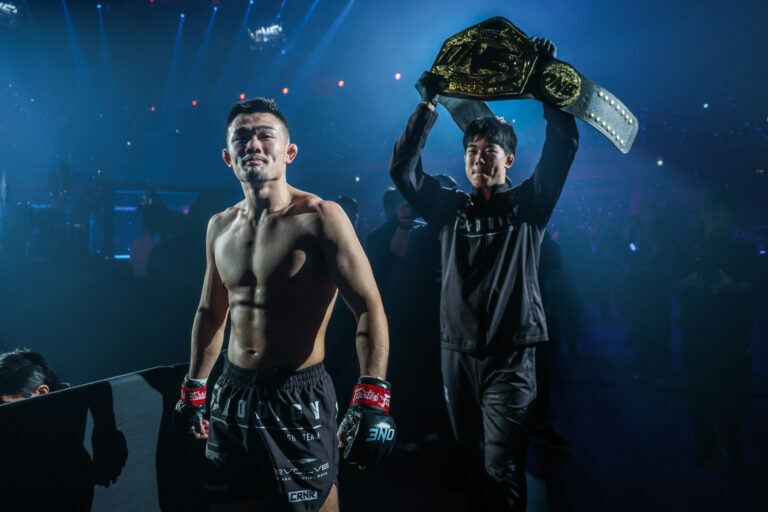 Christian Lee walks backstage with his brother Adrian Lee, who holds the ONE Championship belt